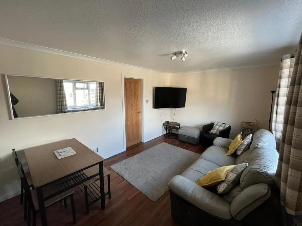 a living room with a couch and a table at 26 Two bedroom apt with private garden in Culloden