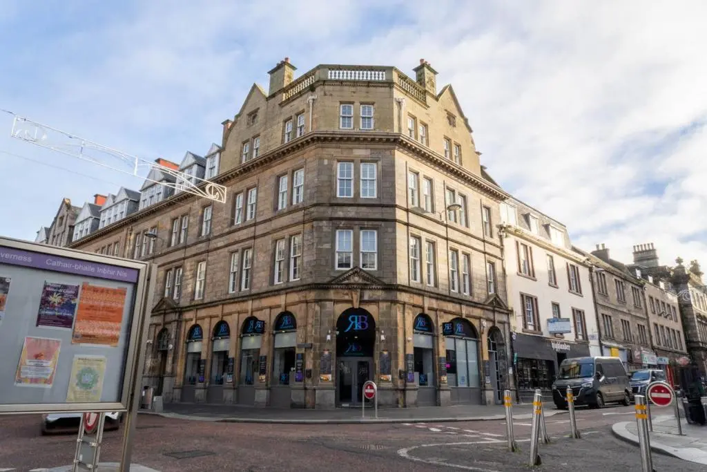 a large brick building on a city street at Church Street Apartment in Inverness