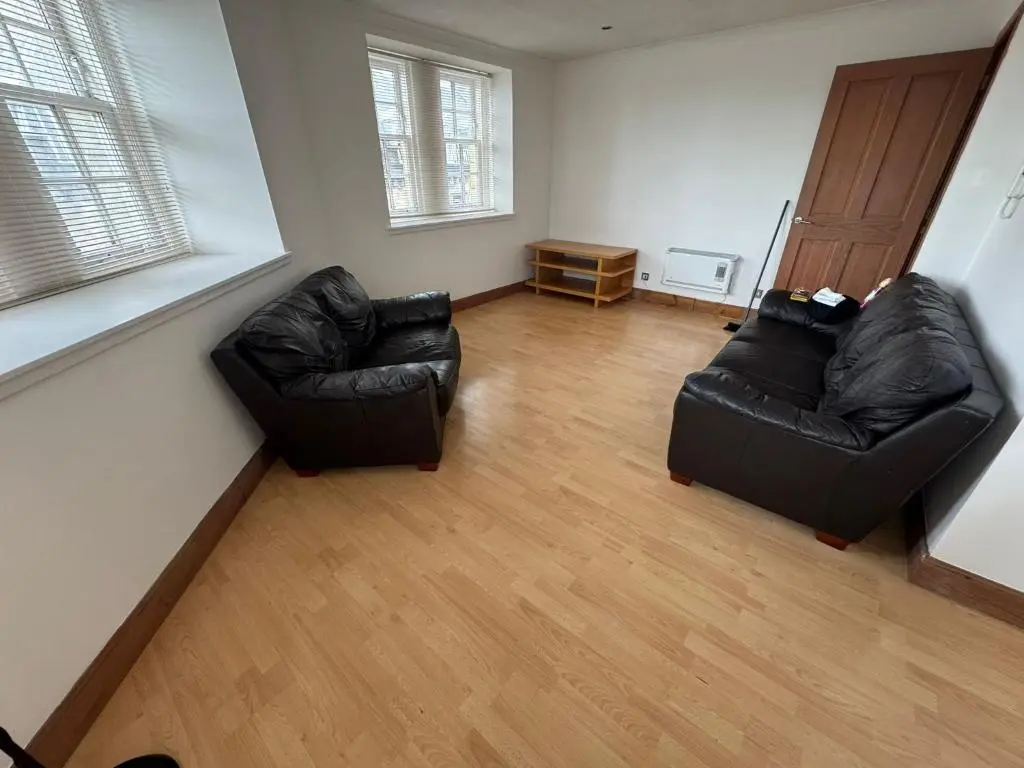 two black leather chairs in a living room with wood floors at Church Street Apartment in Inverness
