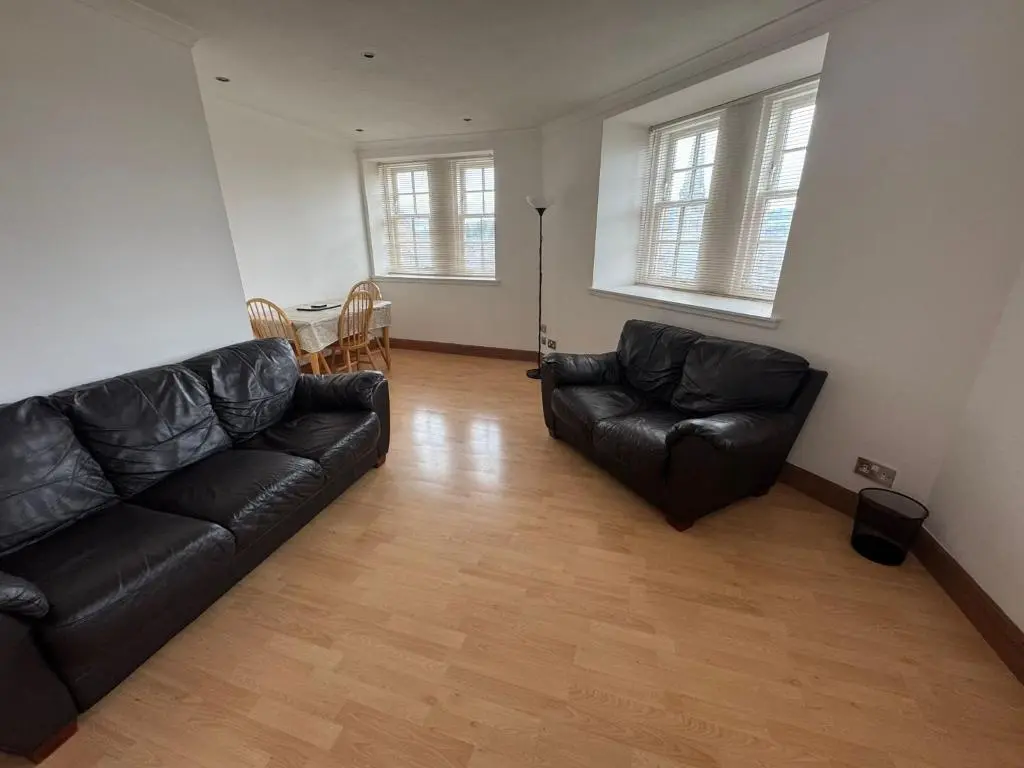 a living room with a black couch and chairs at Church Street Apartment in Inverness