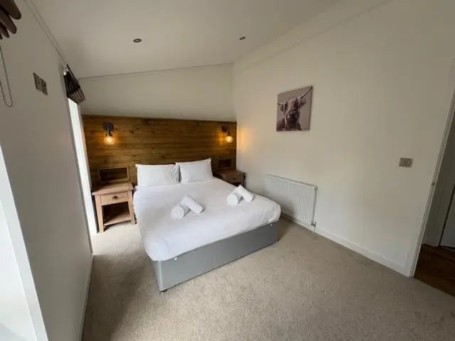 a bedroom with a white bed in a room at Loch Ness Highland Resort in Fort Augustus