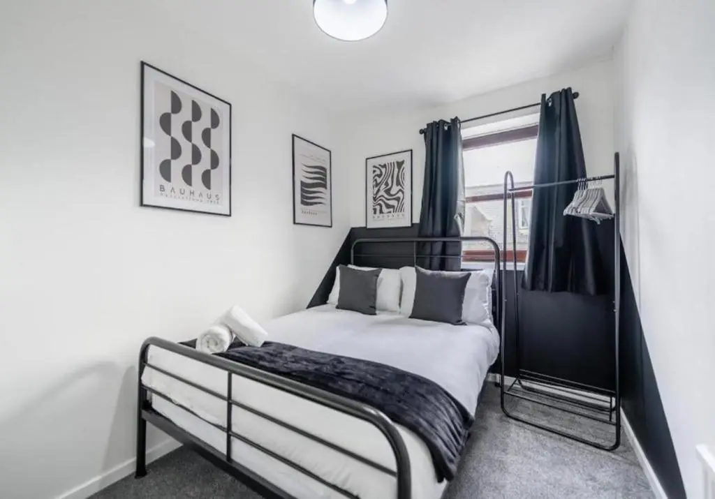 a bedroom with a black and white bed and a window at Bright & Spacious 2BR Fraserburgh for Work & Family Stays in Fraserburgh