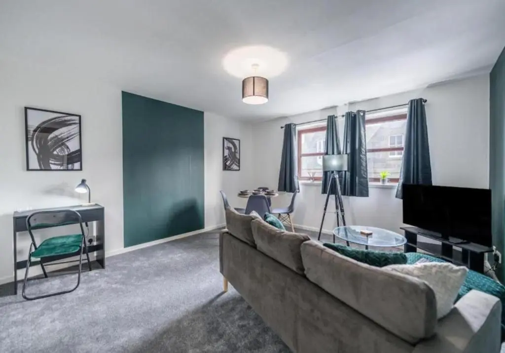 a living room with a couch and a television at Bright & Spacious 2BR Fraserburgh for Work & Family Stays in Fraserburgh