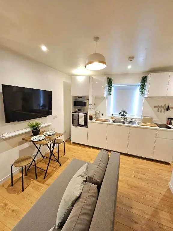 a living room with a couch and a kitchen at Inverness City Centre Studio Flat in Inverness