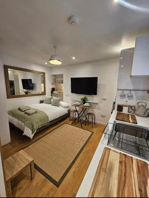a bedroom with a bed and a tv on the wall at Inverness City Centre Studio Flat in Inverness