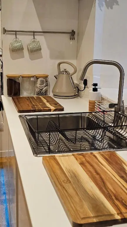 a kitchen sink with a metal dish drying rack at Inverness City Centre Studio Flat in Inverness