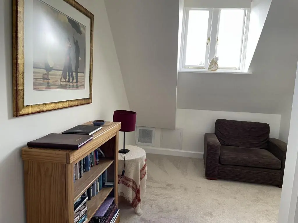 a living room with a chair and a table with books at Monastery 17 in Fort Augustus