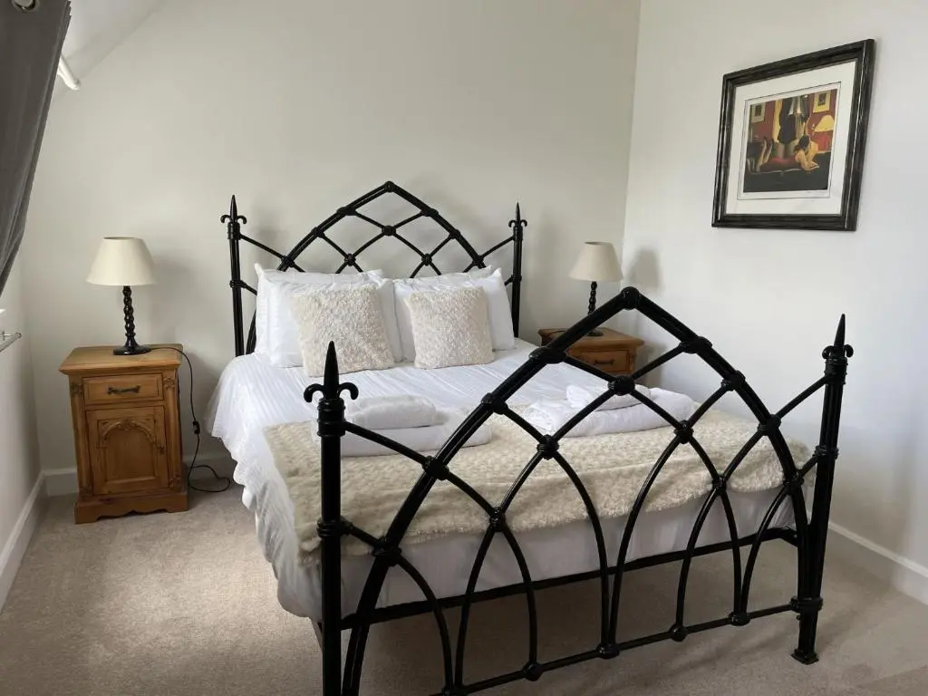 a bedroom with a black bed with white sheets and pillows at Monastery 17 in Fort Augustus