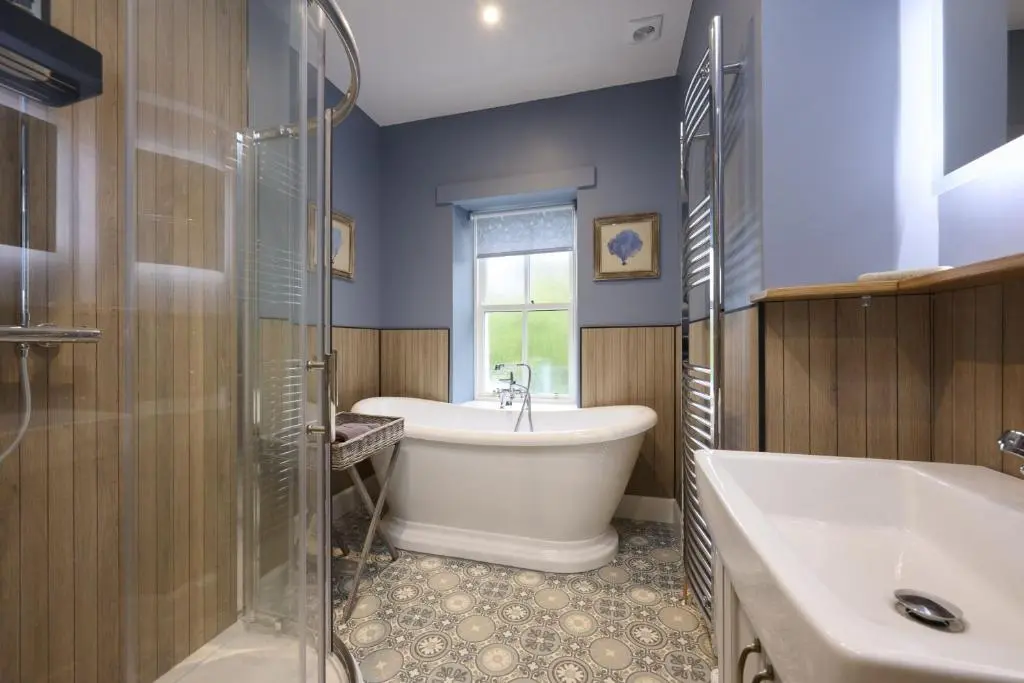 a bathroom with a tub and a sink and a bath tub at Church Cottage in Inverness