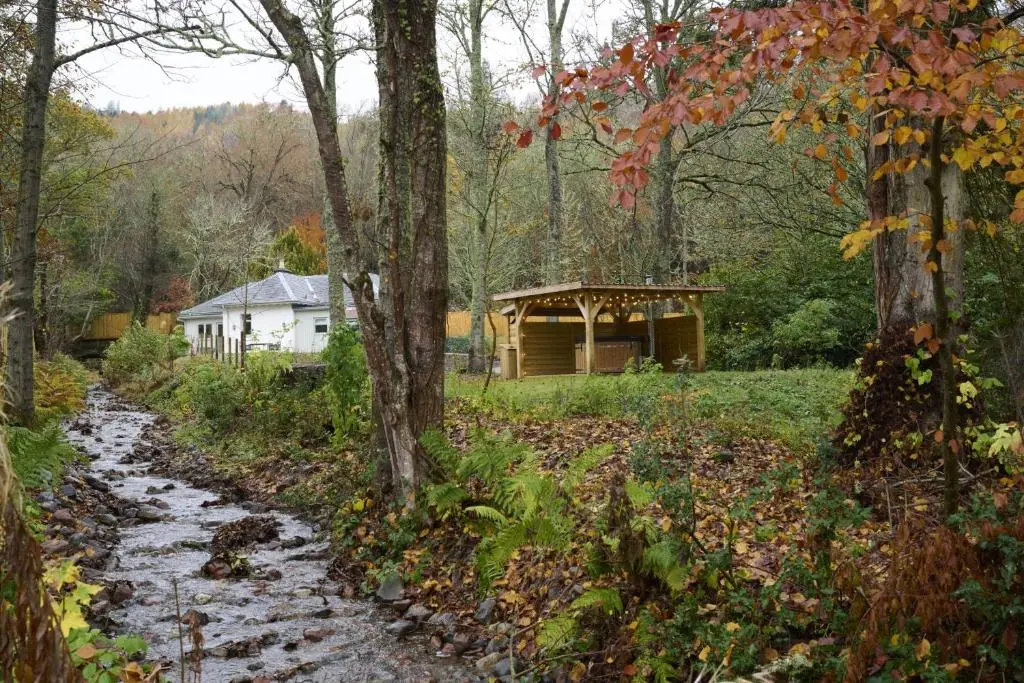 a path leading to a cabin in the woods at Church Cottage in Inverness