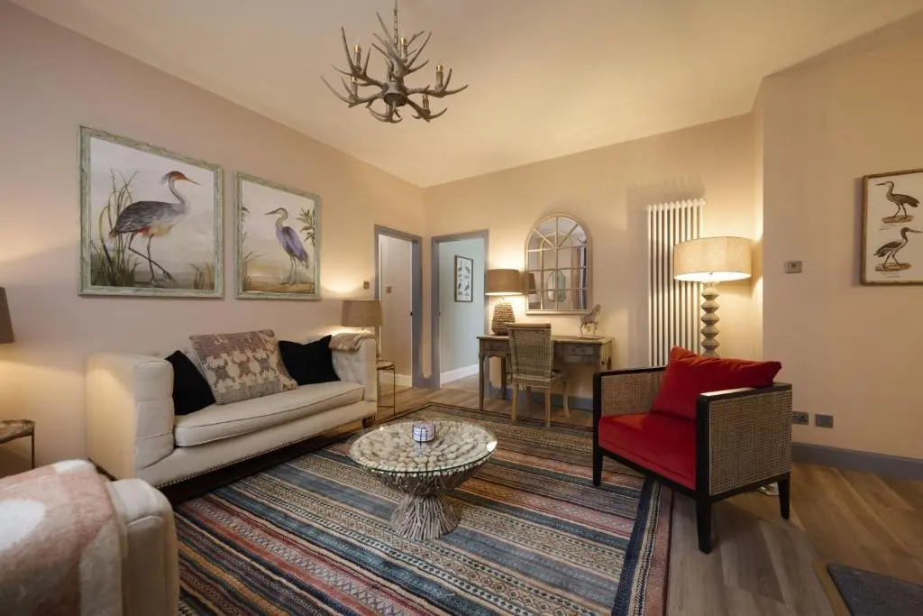 a living room with a couch and a red chair at Church Cottage in Inverness