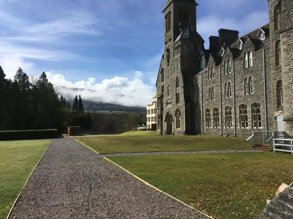 a large stone building with a grass yard at Moat House 1 in Fort Augustus