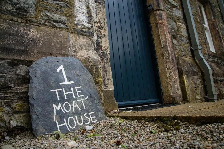 a sign on a rock in front of a building at Moat House 1 in Fort Augustus