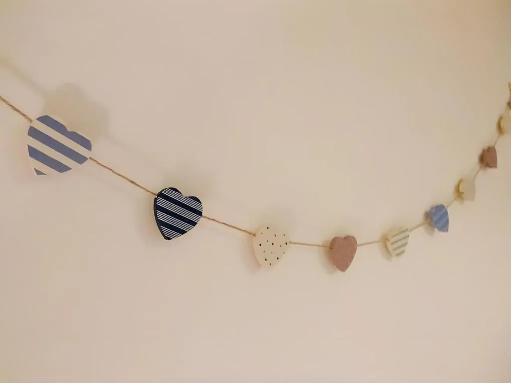 a string of different colored hearts on a white wall at Carn Mhor Lodge in Aviemore