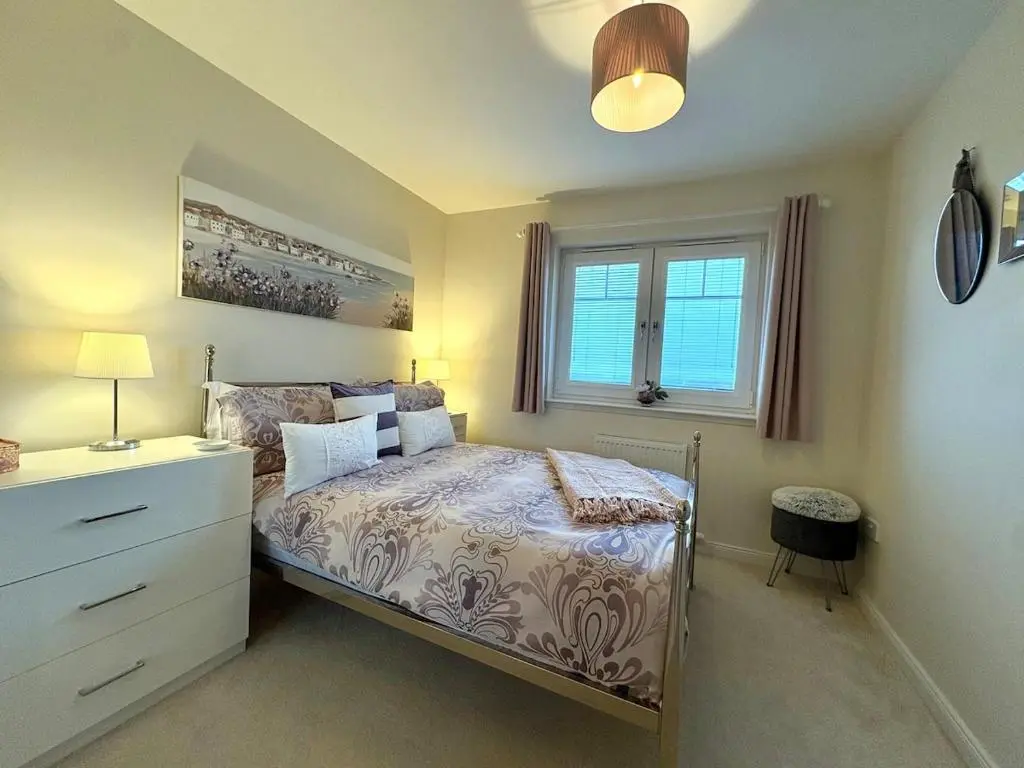 a bedroom with a bed with a dresser and a window at Primrose View House in Inshes