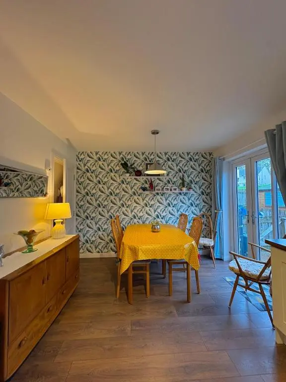 a dining room with a yellow table and chairs at Primrose View House in Inshes
