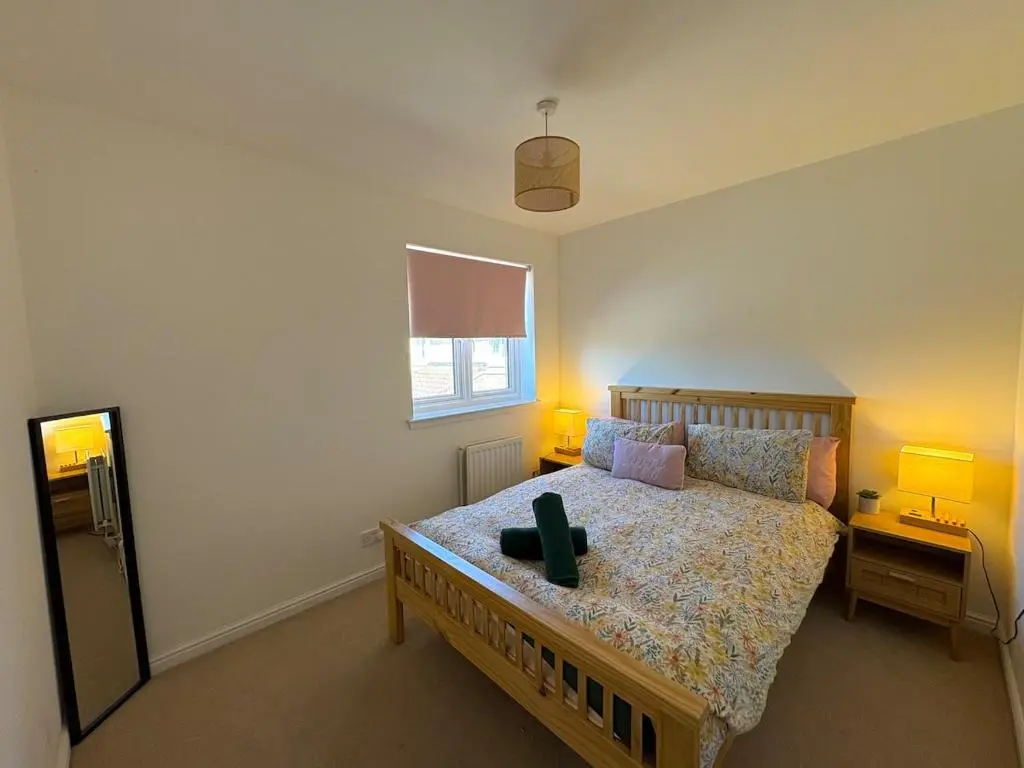 a bedroom with a bed with two lamps on it at Peaceful Abode in Inshes