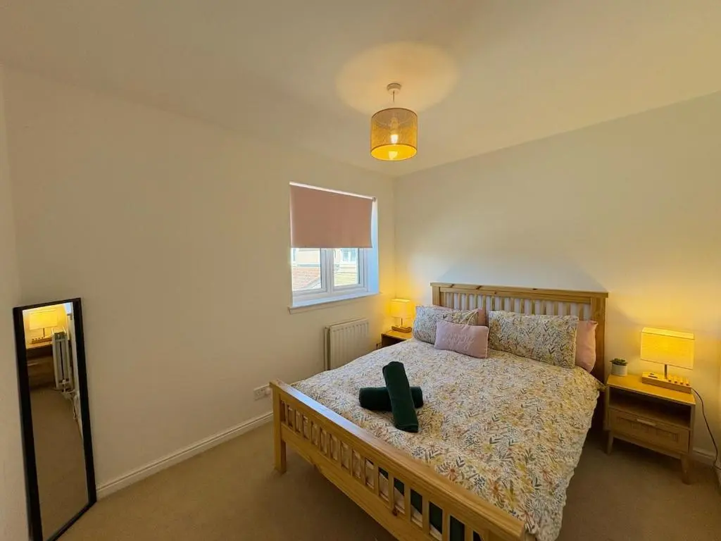 a bedroom with a bed with a green object on it at Peaceful Abode in Inshes
