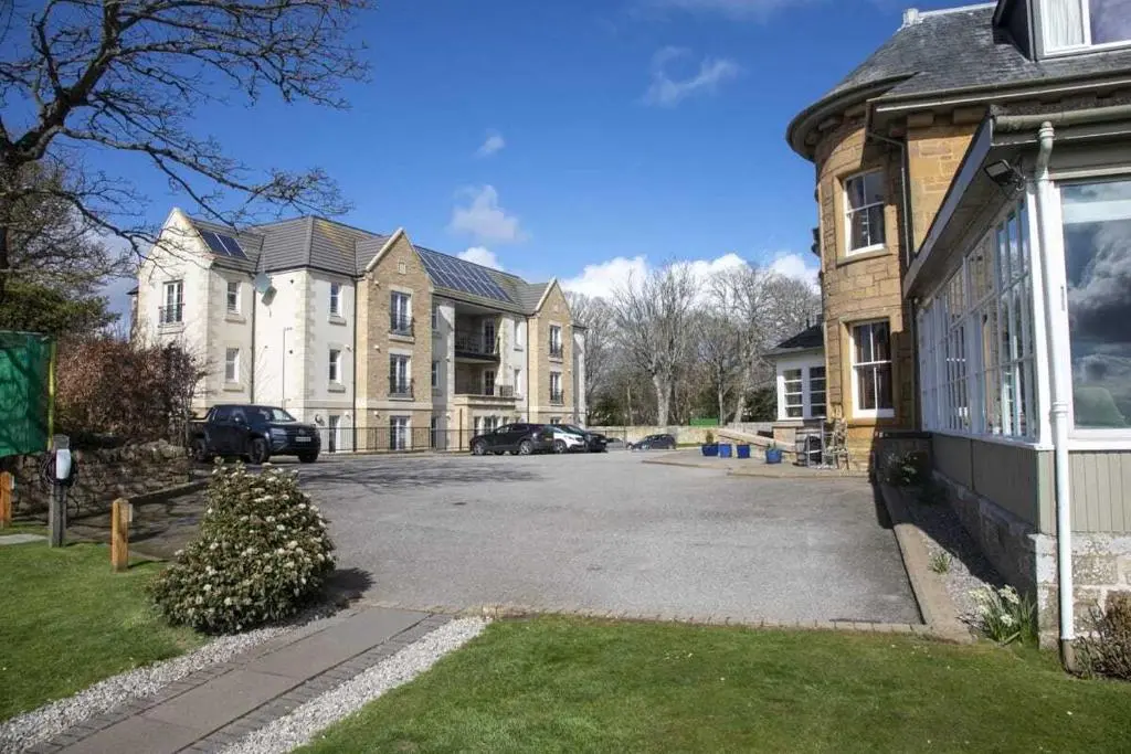 a parking lot in front of a large house at Royal Gardens Apartment 19 in Dornoch