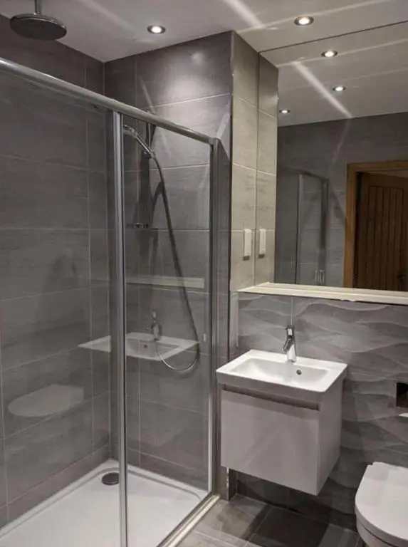 a bathroom with a shower and a sink and a toilet at Royal Gardens Apartment 2 in Dornoch
