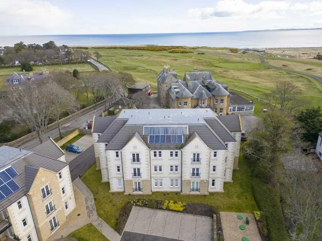 an aerial view of a large house with solar panels at Royal Gardens Apartment 2 in Dornoch