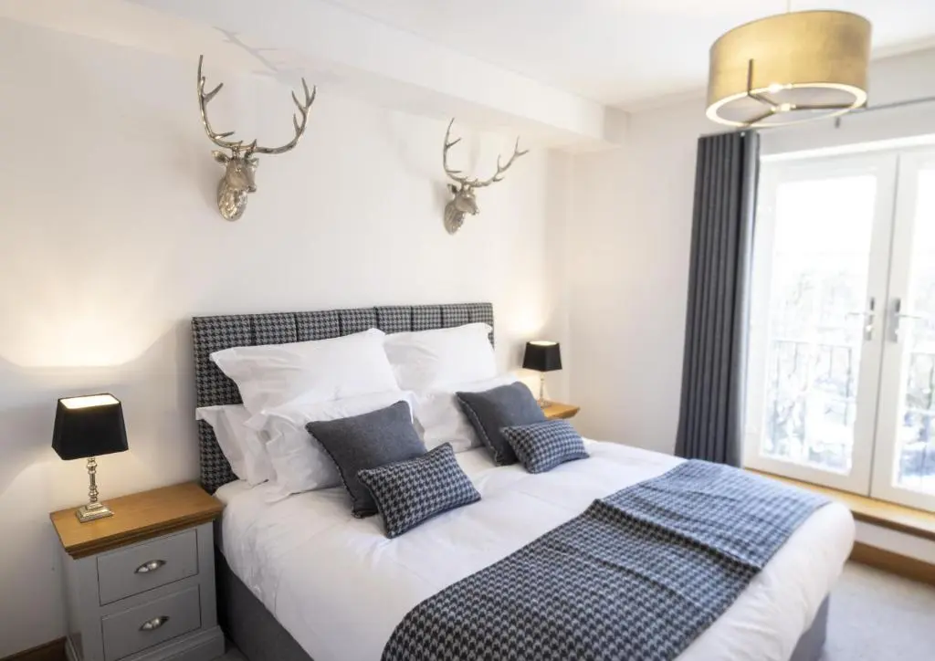a bedroom with a bed with antlers on the wall at Royal Gardens Apartment 10 in Dornoch