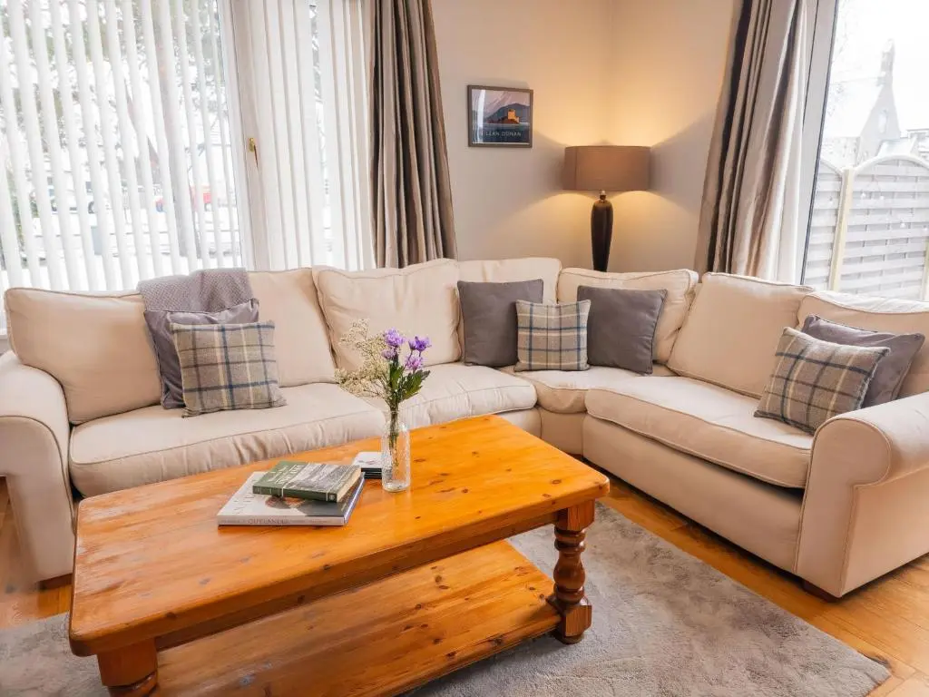a living room with a couch and a coffee table at Loramore in Aviemore