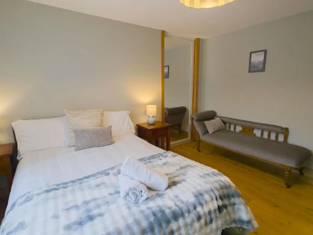 a bedroom with a bed with towels on it at Loramore in Aviemore