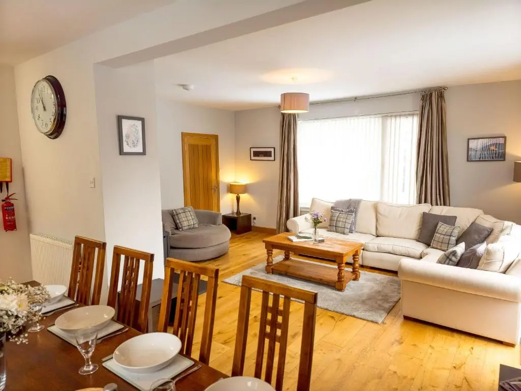 a living room with a couch and a table at Loramore in Aviemore