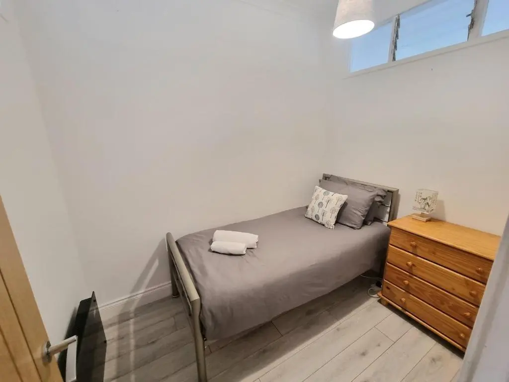 a bedroom with a bed with two towels on it at 2 bedroom flat- 5 minutes walk from city centre in Inverness