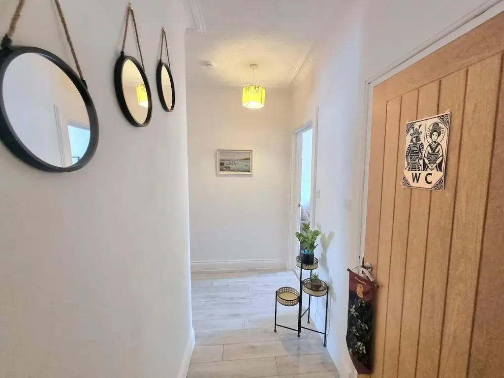 a hallway with a wooden door and a mirror at 2 bedroom flat- 5 minutes walk from city centre in Inverness