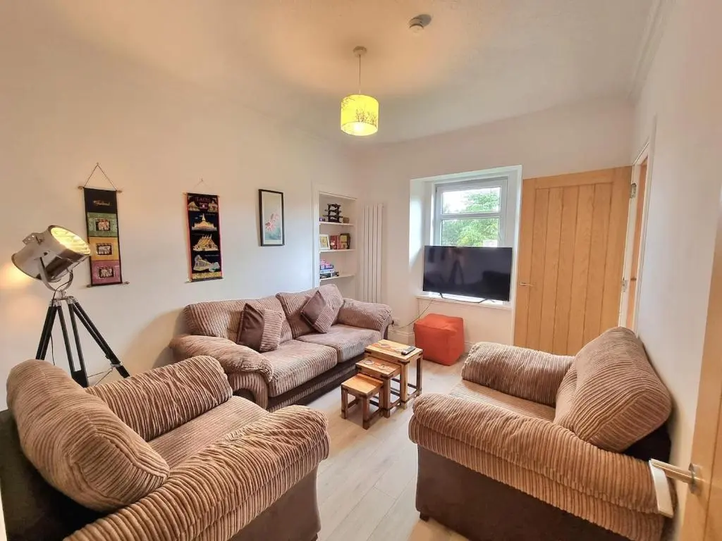 a living room with two couches and a television at 2 bedroom flat- 5 minutes walk from city centre in Inverness