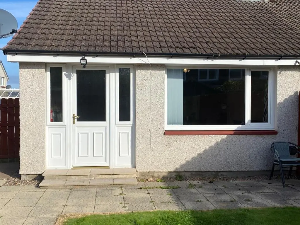 a white door on the side of a house at Highland haven, free parking on driveway, near Raigmore Hospital in Inshes