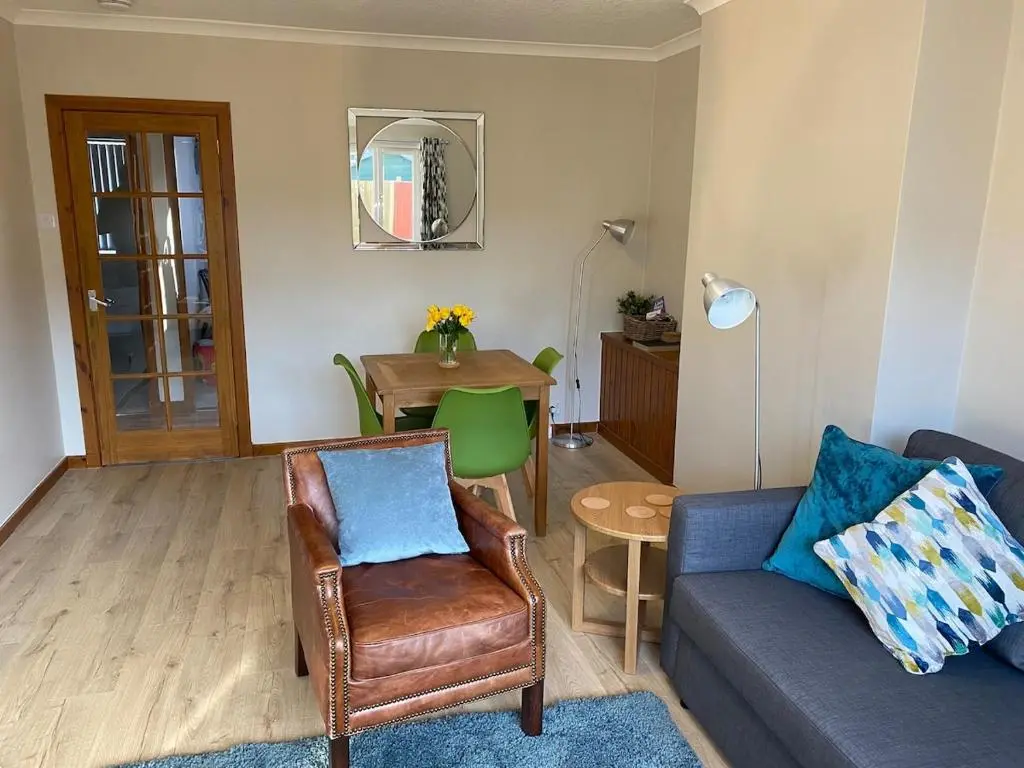 a living room with a couch and a table at Highland haven, free parking on driveway, near Raigmore Hospital in Inshes