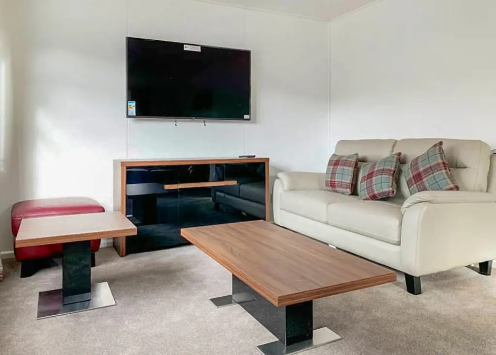 a living room with a couch and a tv at Calvine Holiday Park in Pitlochry