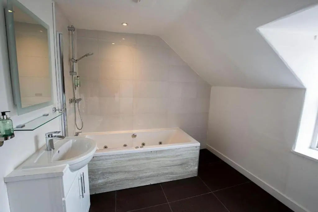 a bathroom with a sink and a bath tub at Crown Hotel & Bar in Inverness