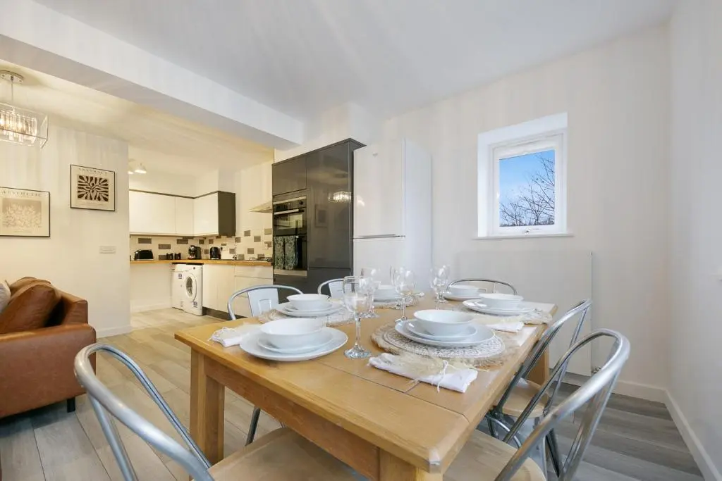 a dining room with a wooden table and chairs at Rooemah Lodge - Grampian Lettings in Caskieben