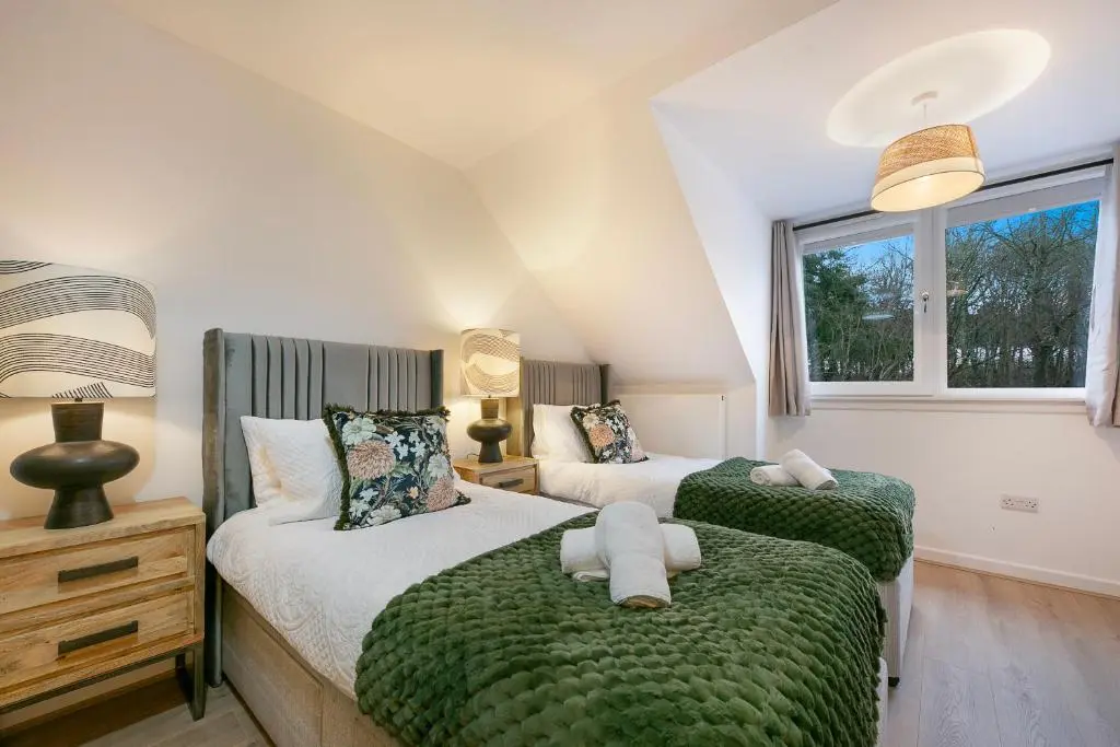 a bedroom with two beds and a window at Rooemah Lodge - Grampian Lettings in Caskieben