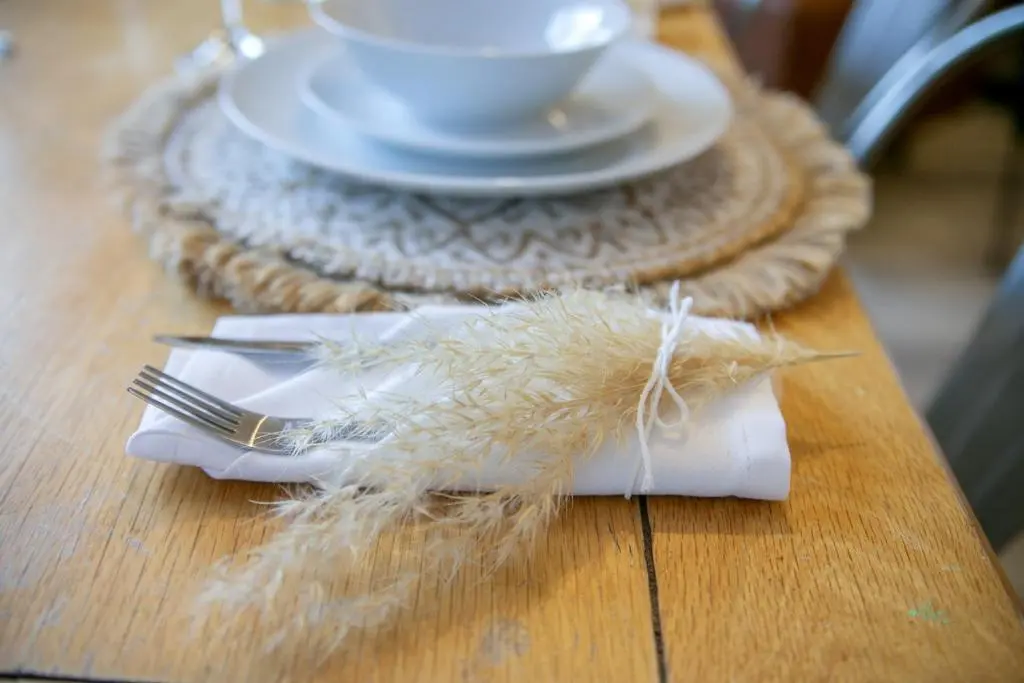 a wooden table with a plate and a fork and a cup at Rooemah Lodge - Grampian Lettings in Caskieben