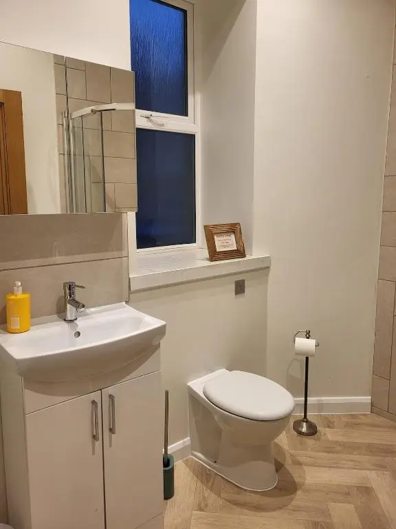 a bathroom with a white toilet and a sink at Gardeners Cottage