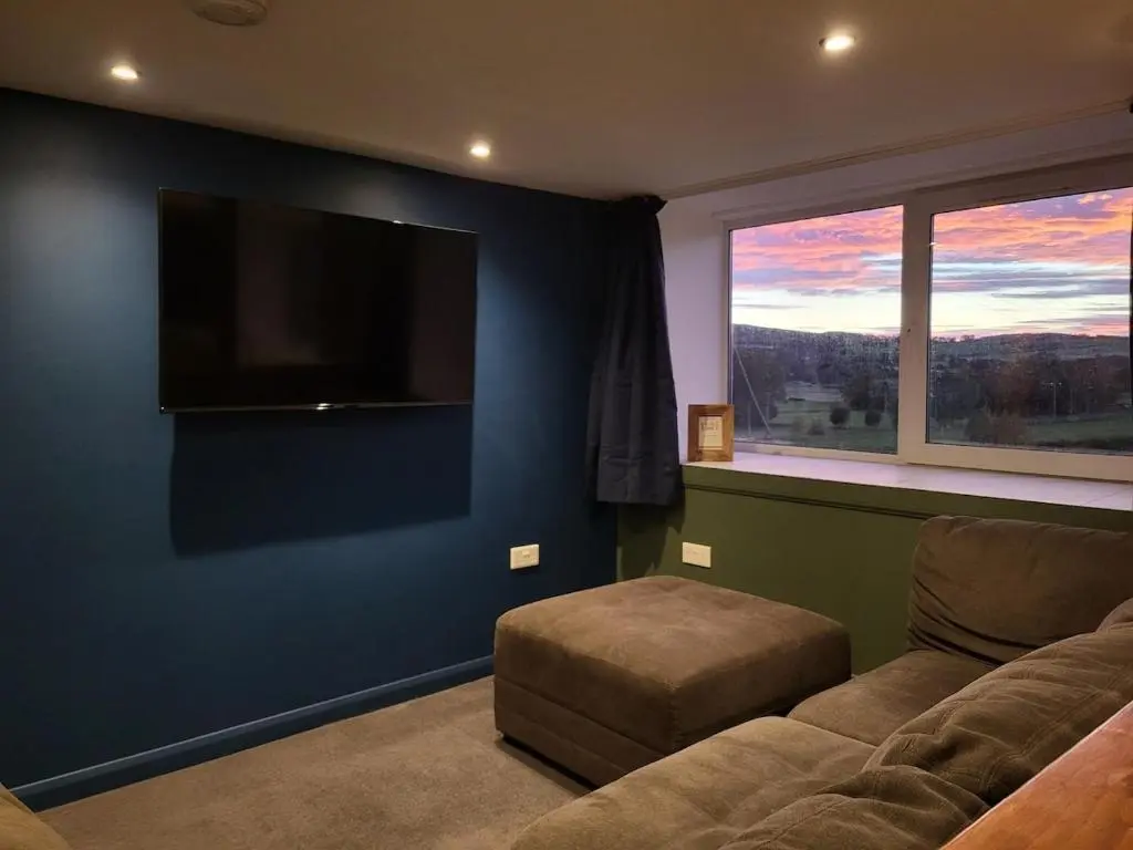 a living room with a couch and a flat screen tv at Gardeners Cottage