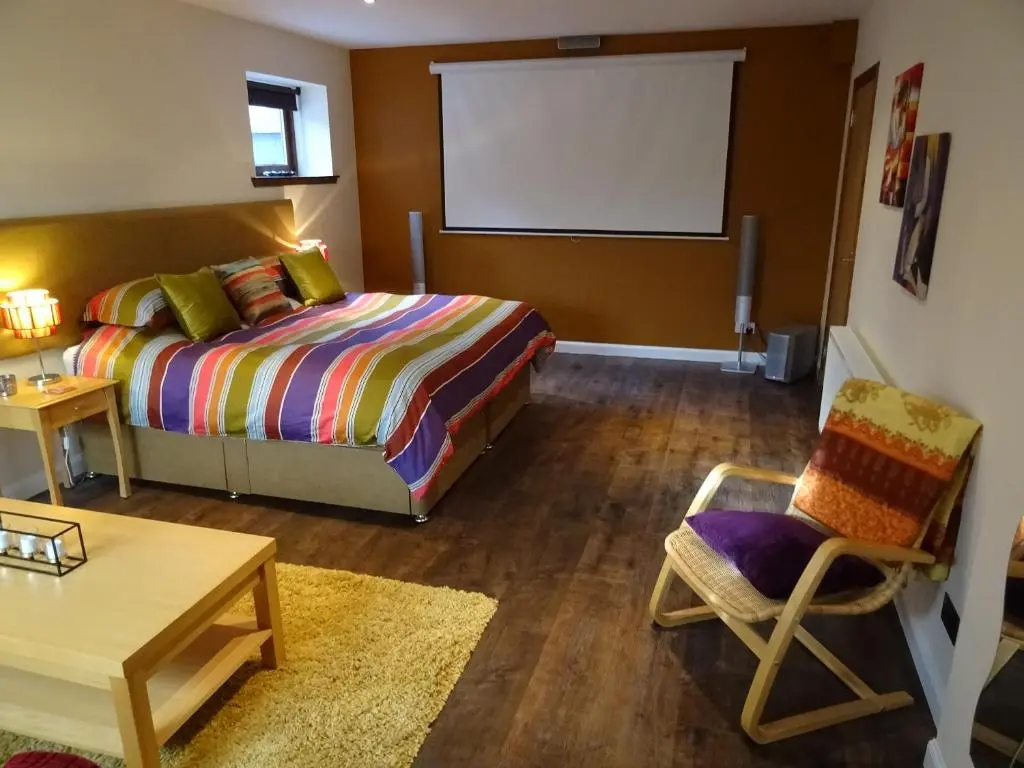 a bedroom with a bed and a chair and a table at 'Le Studio' in Inverness