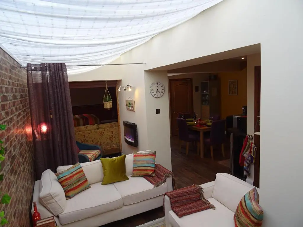 a living room with two white couches and a dining room at 'Le Studio' in Inverness