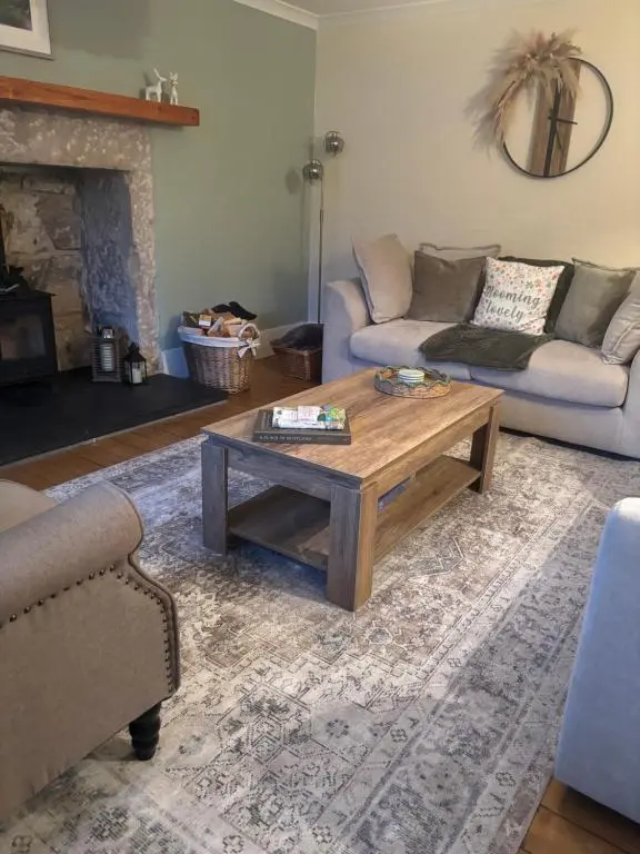 a living room with a couch and a coffee table at Bluebell Cottage in Nairn
