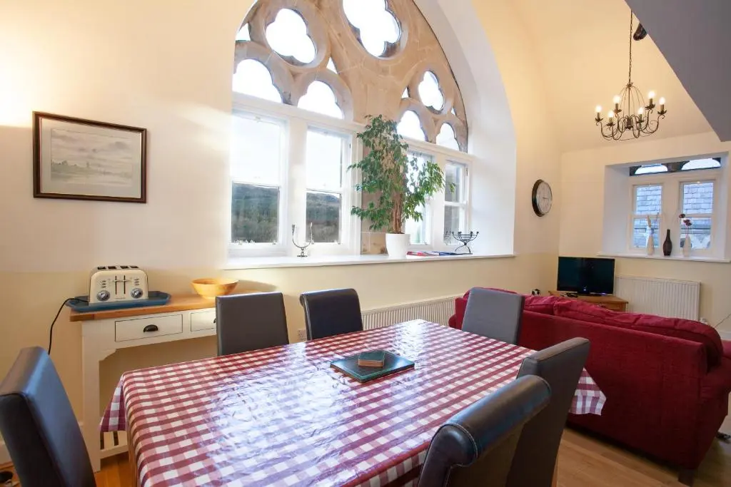 a dining room with a table and some chairs at Old School Apartments Highland Club in Fort Augustus