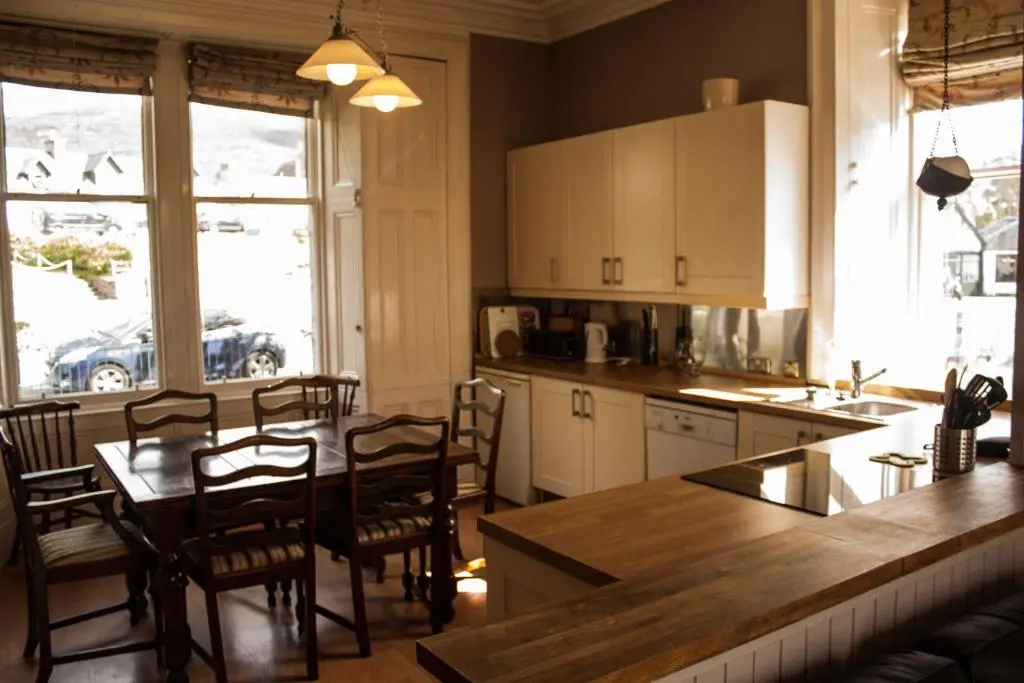 a kitchen with a table and chairs and a counter top at Auld Bank House in Braemar