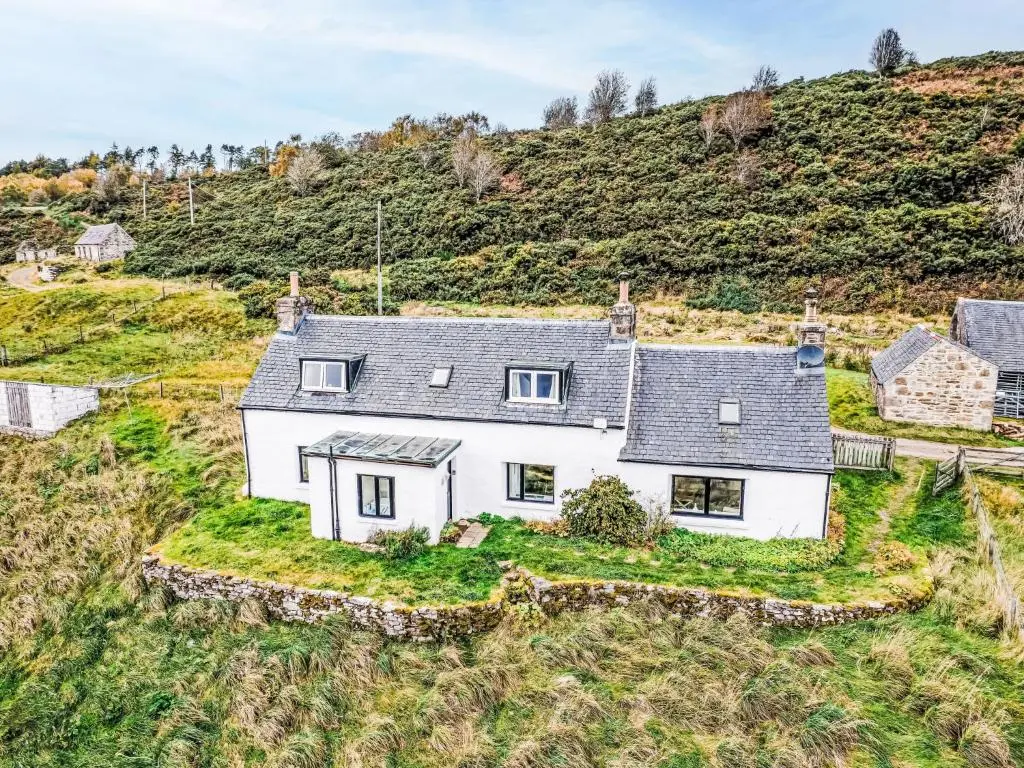 an aerial view of a white house on a hill at Holiday Home Bunloit Farmhouse by Interhome in Drumnadrochit