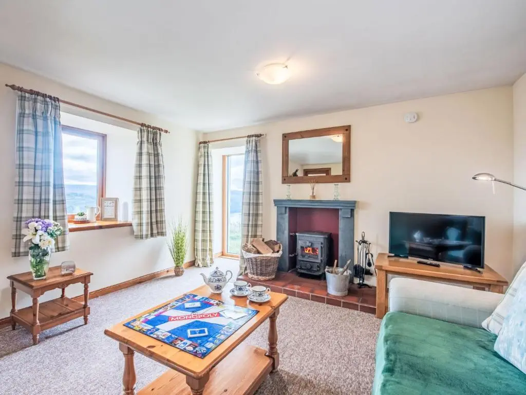 a living room with a couch and a fireplace at Holiday Home Wester Bunloit by Interhome in Drumnadrochit