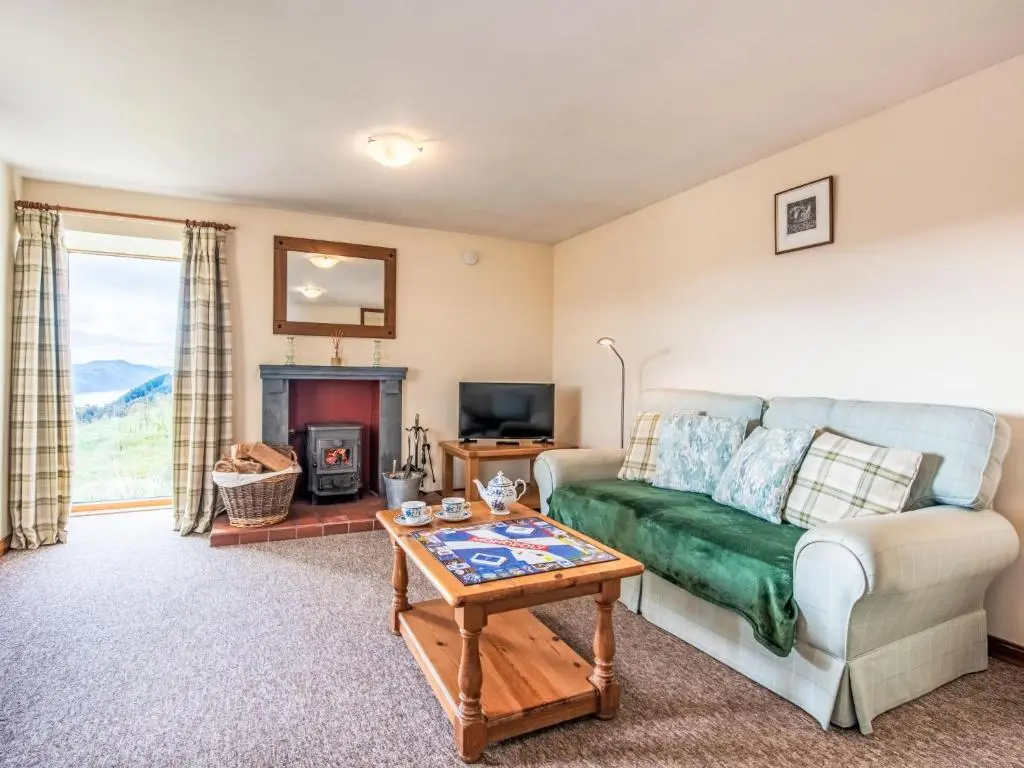 a living room with a couch and a table at Holiday Home Wester Bunloit by Interhome in Drumnadrochit