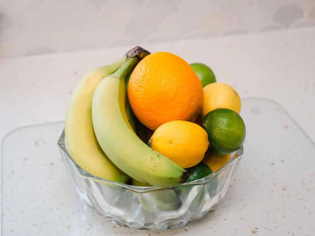 a bowl of fruit with bananas oranges and limes at Holiday Home Cooriedoon by Interhome in Hopeman